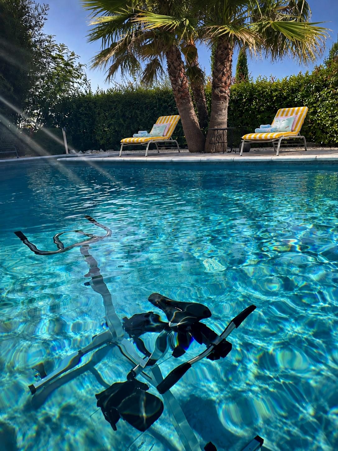 L'aquabike dans la piscine chauffée, face aux transats et aux palmiers