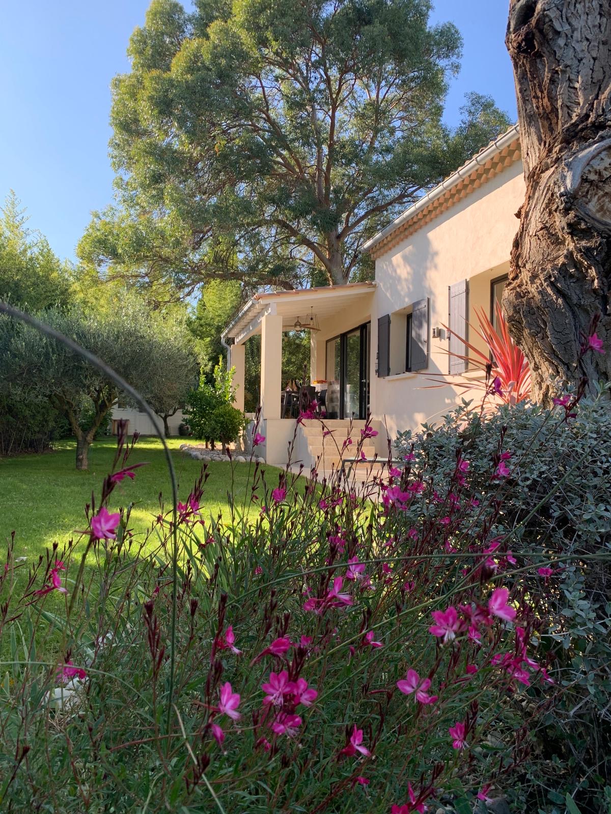 La maison et son jardin fleuri au soleil du matin