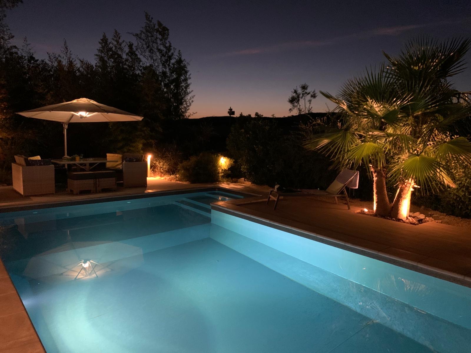La piscine éclairée à la tombée de la nuit